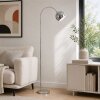 Brilliant Modern Arc floor lamp Helen with curved arm and chrome dome shade beside a sofa